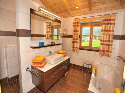 a bathroom with a sink and a tub and a mirror at Wimmerhof in Inzell