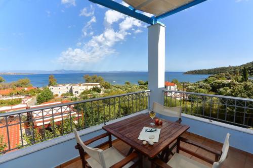 balkon ze stołem i krzesłami oraz widokiem na ocean w obiekcie Vathi Hotel w mieście Vathi