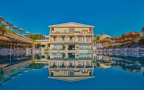 Altura Hotel Zakynthos في تسيليفي: تقديم الشكل الخارجي للمنتجع وانعكاسه في الماء