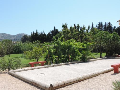 a park with two red benches and trees at Le faré tchanqué chambre d'hôtes, parking gratuit sur place in Cavaillon