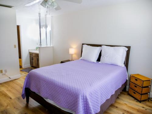 1 dormitorio con 1 cama grande y edredón morado en Spacious Townhome Ocala, Central Location, Newly Renovated, Pets Welcome, en Ocala