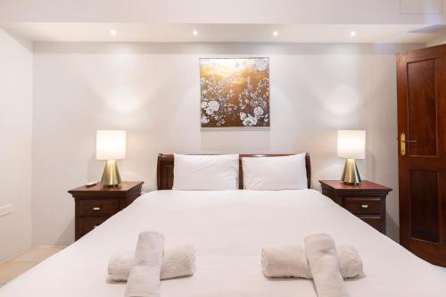 a bedroom with a large white bed with two lamps at Xmajjar in Sliema