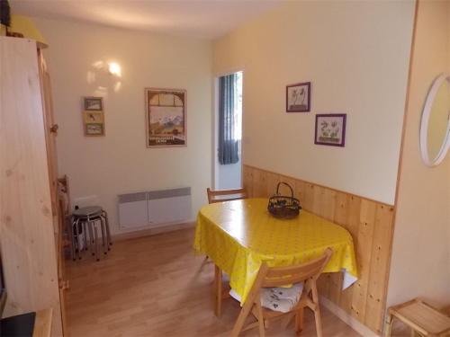 une salle à manger avec une table et des chaises jaunes dans l'établissement Luchon T2 Centre Ville avec Balcon Sud et Parking - Animaux Admis - FR-1-313-194, à Luchon