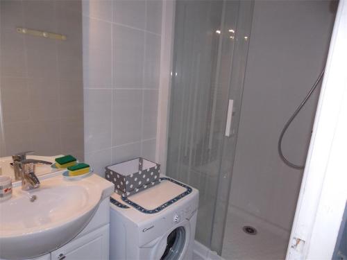 une salle de bain avec douche et lavabo et une machine à laver dans l'établissement Luchon T2 Centre Ville avec Balcon Sud et Parking - Animaux Admis - FR-1-313-194, à Luchon