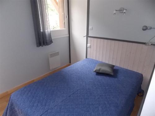 - une chambre dotée d'un lit bleu avec un oreiller dans l'établissement Luchon T2 Centre Ville avec Balcon Sud et Parking - Animaux Admis - FR-1-313-194, à Luchon