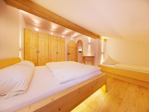 a large bed in a room with wooden walls at Wimmerhof in Inzell