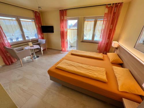 um quarto com 2 camas, uma mesa e janelas em Hotel-Heilsberg em Gottmadingen