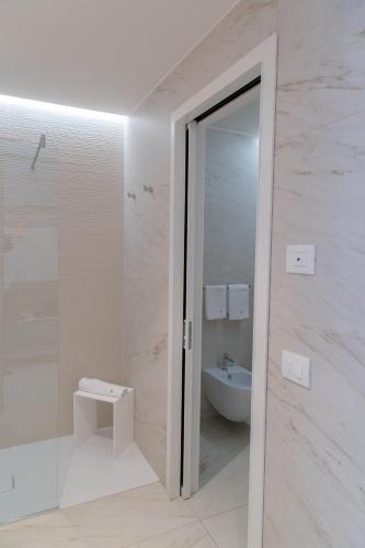 a bathroom with a shower and a sink and a toilet at THE ONE CAORLE - Hotel & Apartments in Caorle