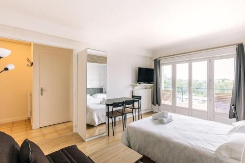 une chambre d'hôtel avec un lit, une table et des chaises dans l'établissement Marvellous Studio Paris 14, à Gentilly