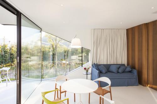 a living room with a couch and a table and chairs at Mirror Houses in Bolzano
