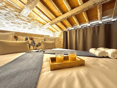 two glasses of orange juice sitting on a bed at Torre Medieval de Queralt y Spa in Concabella