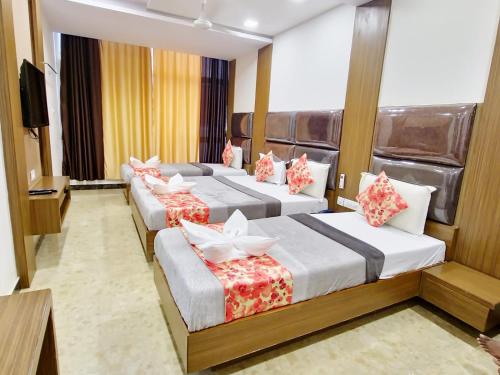 a hotel room with three beds and a television at Sheraton Grande at Puratchi Thalaivar Dr MGR Central Railway Station in Chennai