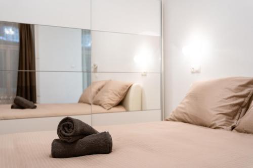 una camera d'albergo con un asciugamano su un letto con uno specchio di Central Seven Erzsebet Krt a Budapest