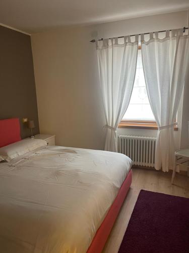 Un dormitorio con una cama grande y una ventana en Appartamento Serenella en Pontagna
