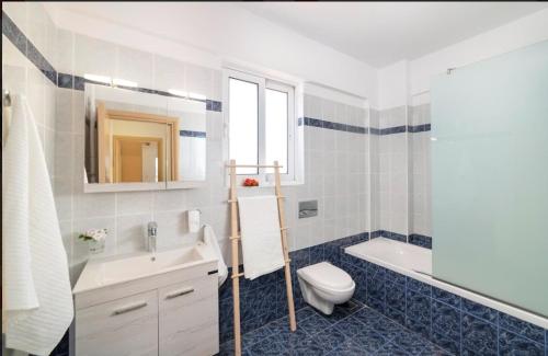 a bathroom with a sink and a toilet and a tub at Villa Kermes Heated Pool in Kournás