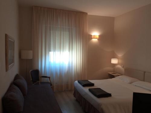 a hotel room with a bed and a window at Hotel Touring in Livorno