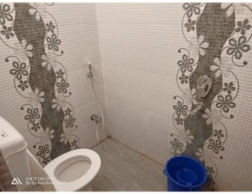 uma casa de banho com um WC com um mural de árvore na parede em Hotel Diamond Vihar, Rajgir em Rajgir