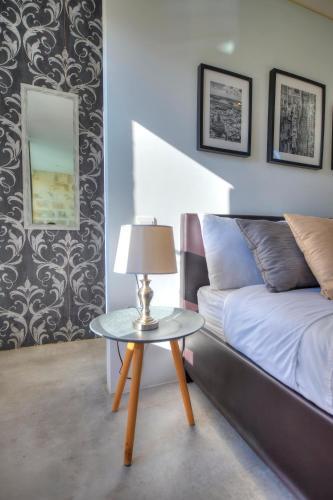 a bedroom with a bed and a table with a lamp at Casa Bartolo A Hidden Gem - Spacious Village Home EBAR1-1 in Lija