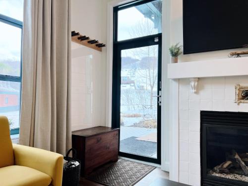 a living room with a fireplace and a yellow chair at Mountain Creek Resort at Appalachian Hotel - Pool & Hot Tub in Vernon Township