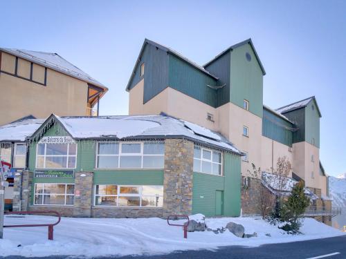 een groot gebouw met sneeuw op het dak bij Vacancéole - Les Balcons du Soleil in Germ