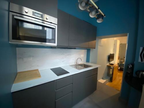 a kitchen with a sink and a microwave at Studio Aboukir 1 in Paris