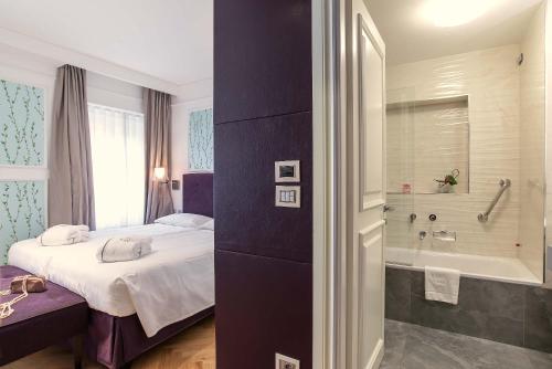 a bedroom with a bed and a bath tub at Hotel Damaso in Rome