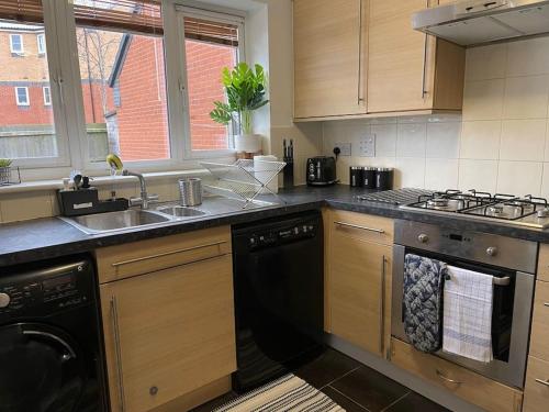 a kitchen with a sink and a stove and a dishwasher at Plantsbrook Place - Luxury 4 bed House + Parking in Birmingham