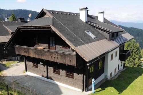 an old wooden house with a gambrel roof at Alpenhäuser Marcius in Sonnenalpe Nassfeld