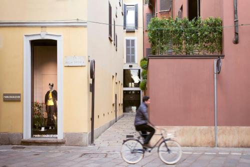 Ein Mann, der eine Straße entlangfährt in der Unterkunft Spiga Duplex Suites by Montenapoleone Living in Mailand
