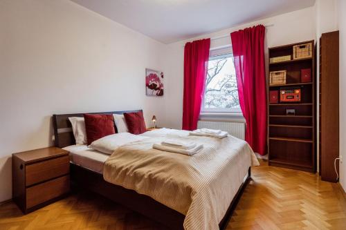 um quarto com uma cama grande e cortinas vermelhas em Citadel Manor Apartment em Budapeste