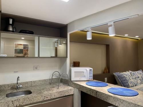 a kitchen with a sink and a microwave on a counter at Pipa's Bay - Flats para temporada in Pipa