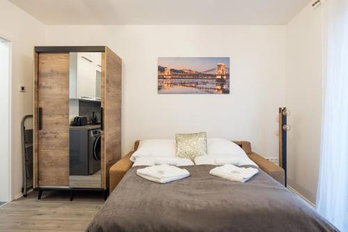 a bedroom with a bed with two towels on it at Central Sphere Apartment in Budapest