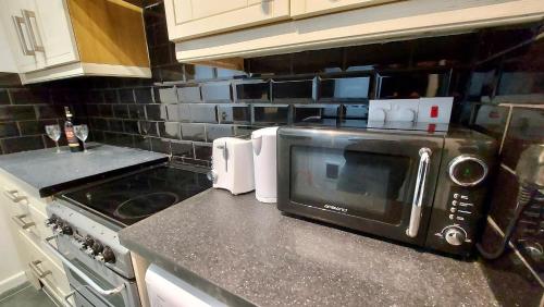 a kitchen with a microwave on top of a counter at Large 4 bedroom / 7 guests house in Doncaster