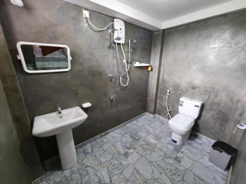 a bathroom with a shower and a sink and a toilet at King CoCo House in Dickwella