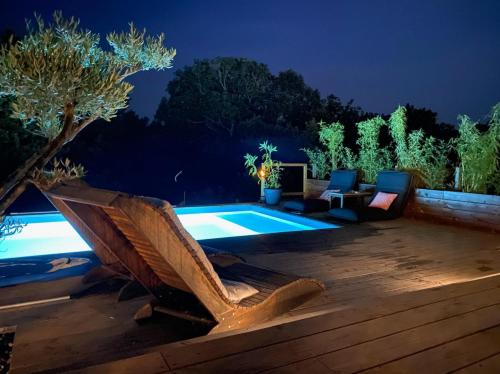 a backyard with a swimming pool at night at Villa Parenthèse in Saint Alban Auriolles