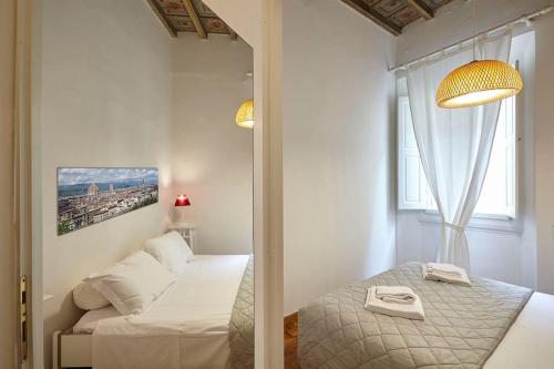 ein kleines Zimmer mit einem Bett und einem Spiegel in der Unterkunft Sant'Ambrogio Studio in Florenz