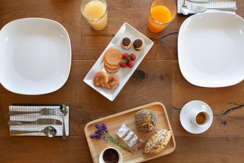 a table with a plate of breakfast foods and orange juice at 21Barra5 Guest House in Aosta