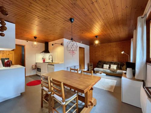 a kitchen and living room with a wooden ceiling at Vacances COURCHEVEL/les 3 Vallées in Bozel