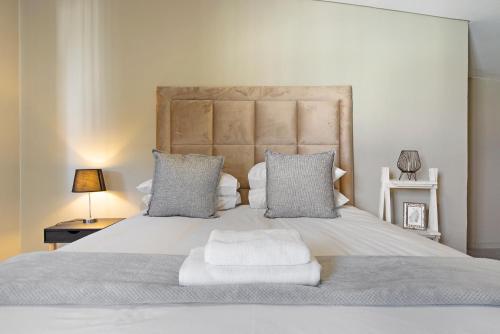 ヨハネスブルグにあるUrban Oasis Apartments at The Boltonのベッドルーム1室(大きな白いベッド1台、枕2つ付)