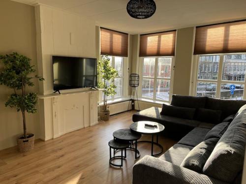 a living room with a couch and a flat screen tv at Appartement centrum Leeuwarden in Leeuwarden