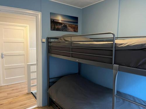 2 łóżka piętrowe w niebieskim pokoju z drzwiami w obiekcie Appartement centrum Leeuwarden w mieście Leeuwarden