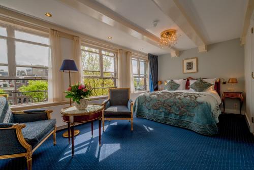 فندق أمباساد في أمستردام: غرفة نوم بسرير وطاولة وكراسي