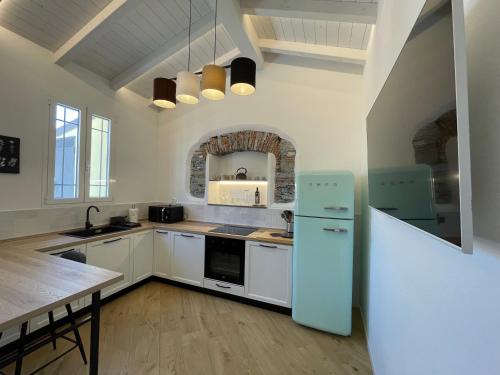 a kitchen with white cabinets and a blue refrigerator at SUN Luxury Apartment in Centro Storico in Chiavari