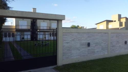 una valla con una puerta delante de un edificio en Departamentos Blanc en Colón