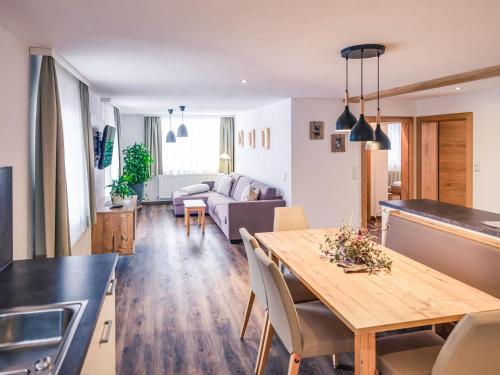 a kitchen and living room with a table and a couch at Haus Kristall in Tannheim