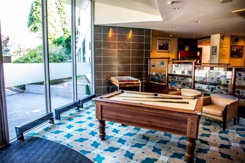 a room with a pool table in the middle of it at Mercure Chester Abbots Well Hotel in Chester