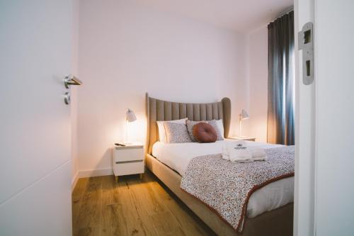 ein Schlafzimmer mit einem Bett und einem Nachttisch mit einer Lampe in der Unterkunft Best Houses 30 - Terrace Peniche in Peniche