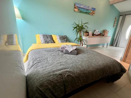 ein Schlafzimmer mit einem großen Bett mit einer grauen Decke in der Unterkunft Gîte Anse Coco Luberon - Au calme, gite avec piscine securisee in Pertuis