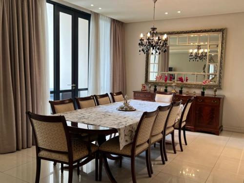 Johannesburg的住宿－Sandton Emperor Apartment，一间带桌椅和镜子的用餐室