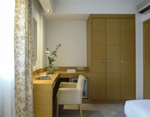 a kitchen with a desk and a chair in a room at Anatolia Hotel in Thessaloniki